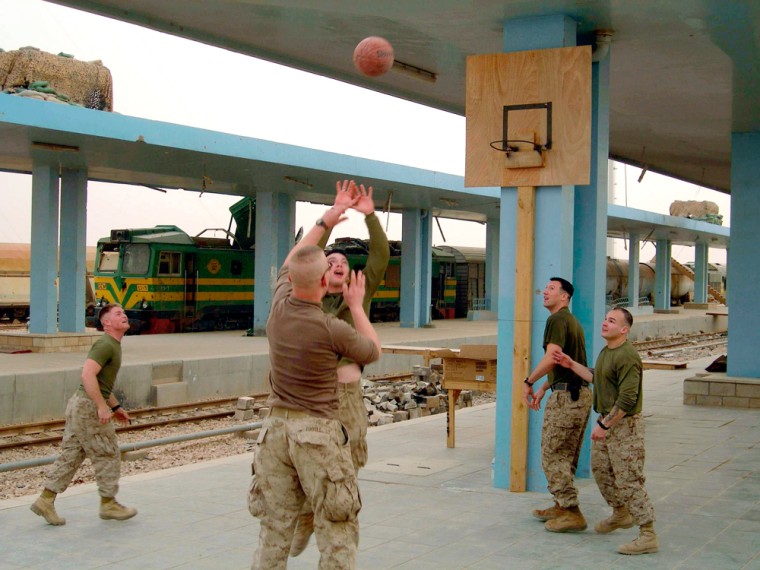 U.S. Marines play basketball on a makeshift court at their base in the western border city of Husaybah, Iraq, on Monday. News of the bombing of the Shiite's most revered shrine took five days to arrive to them.