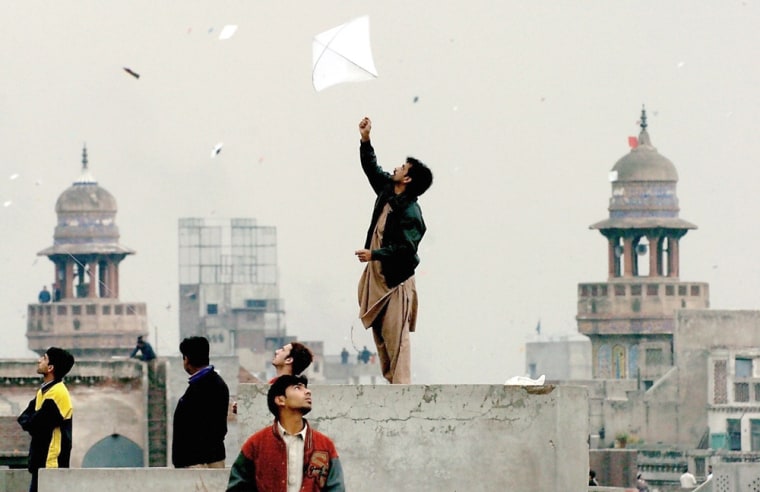 Pakistani youth enjoy flying kites durin