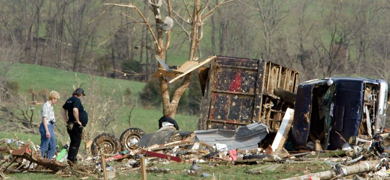 Residents survey what is left of their home after a one of several tornadoes generated by a band of severe weather touched down near St. Mary, Mo., Sunday, March 12, 2006.  Two deaths have been attributed to the tornado.(AP Photo/Tom Gannam)