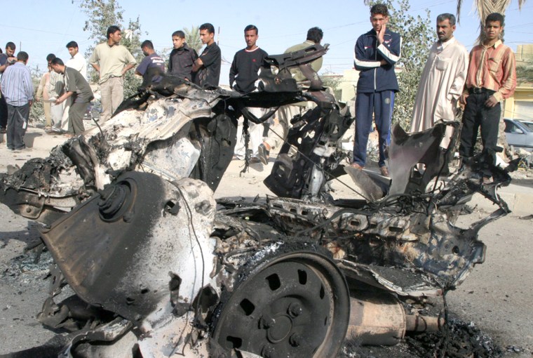 Local residents view remains of vehicle after suicide car bomb attacked US military convoy in Falluja