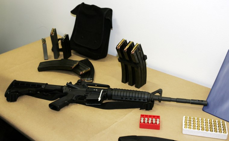 This Bushmaster AR-15 semi-automatic rifle and ammunition, shown Monday, March 27, 2006, at Seattle Police headquarters in Seattle, were among the weapons used by Aaron Kyle Huff when he killed six people and then  comitted suicide at a party in Seattle early Saturday morning. (AP Photo/Ted S. Warren)
