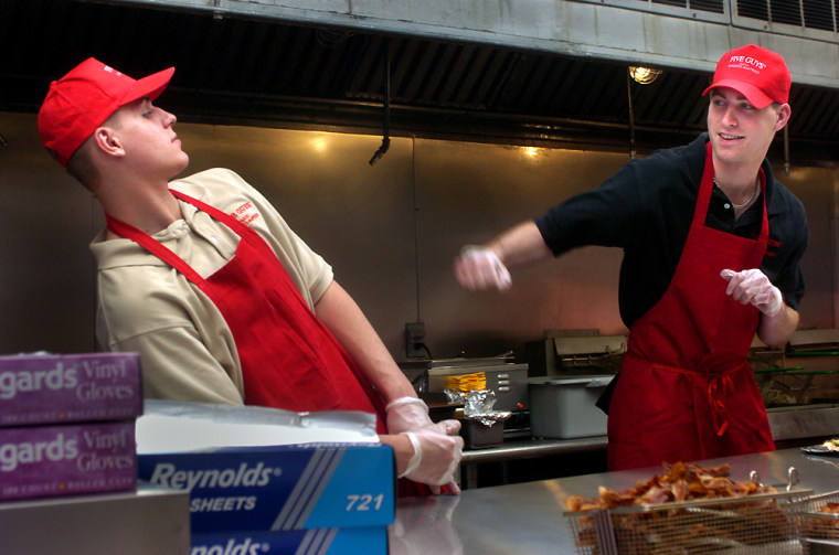 The two youngest members of the Murrell family, Tyler, left, and Ben, display typical brother behavior behind the counter of a Virginia branch of Five Guys Famous Burgers and Fries.
