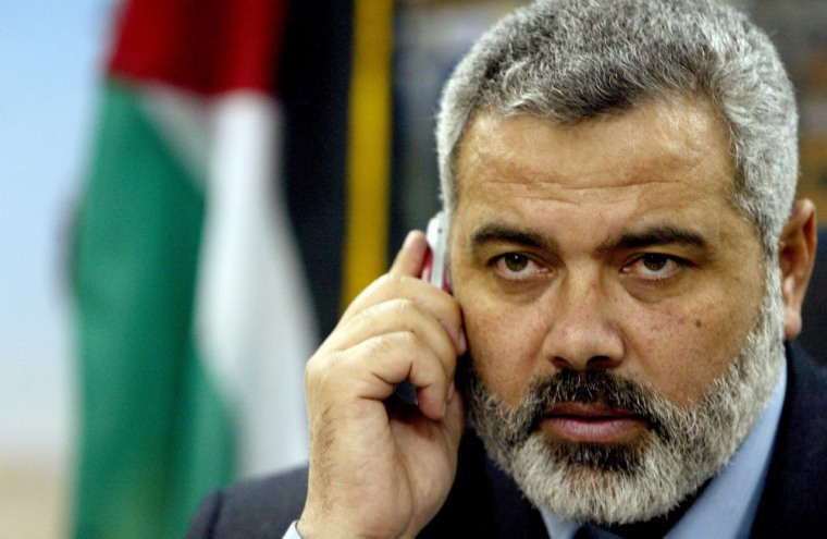 Newly-appointed Palestinian Prime Minister Ismail Haniyeh speaks on his cell phone Sunday in his office at the Council of Ministers, in Gaza City. 