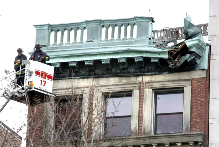 Firefighters survey damage to a building in Boston on Monday after a construction crane and scaffolding collapsed, killing at least three people.