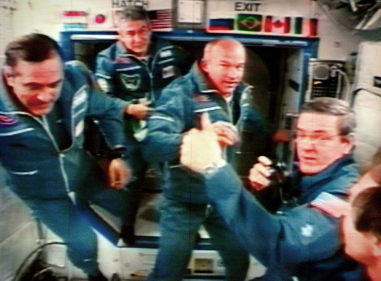 A photograph of a video screen in a control centre shows from left: Russian cosmonaut Pavel Vinogradov, Brazilian astronaut Marcos Pontes, U.S. Jeffrey Williams, and ISS Commander Bill McArthur during a briefing at the International Space Station after the Soyuz TMA8 spacecraft successful docking, at Korolyov, just outside Moscow, Saturday, April 1, 2006. A Soyuz capsule docked with the international space station Saturday, bringing Brazil's first astronaut, a new Russian-American crew and a fresh load of supplies, equipment and experiments. (AP Photo/Mikhial Metzel)
