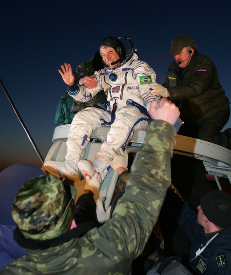 Brazil's first astronaut Marcos Pontes waves after landing near the town of Arkalyk