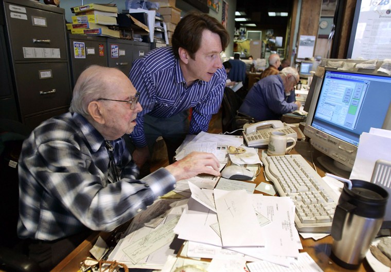 Weil checks invoices against incoming checks with help of his grandson Steve in his office and shop in downtown Denver