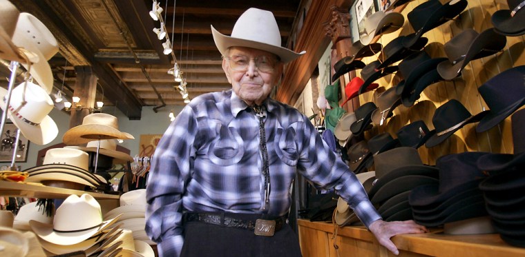 Weil smiles among his hat designs in his office and shop in downtown Denver