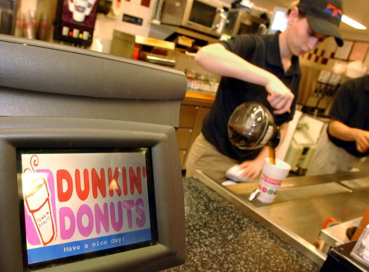 Dunkin' Donuts employee Sandra Manoel pours coffee for a customer in Cambridge, Mass. The company's new advertising campaign is called "America Runs on Dunkin."