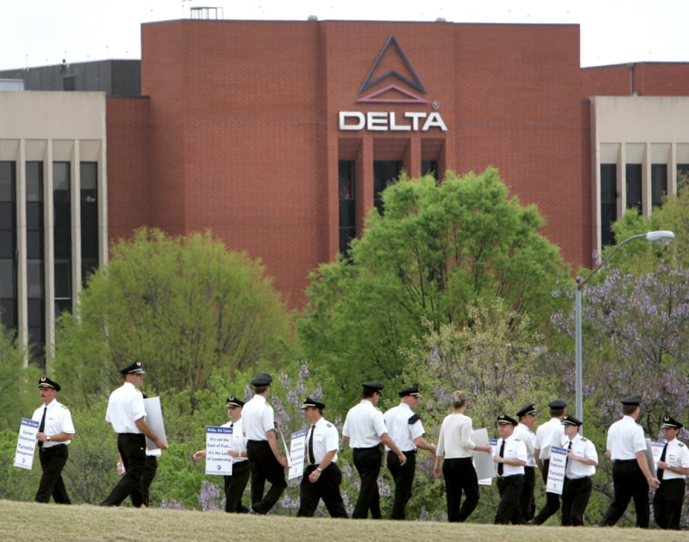 Delta Air Lines pilots walk a picket line near their headquarters on Wednesday. The airline and its pilots union reached a tenative deal that could avert a threatened strike, though it awaits approval from the flyers.