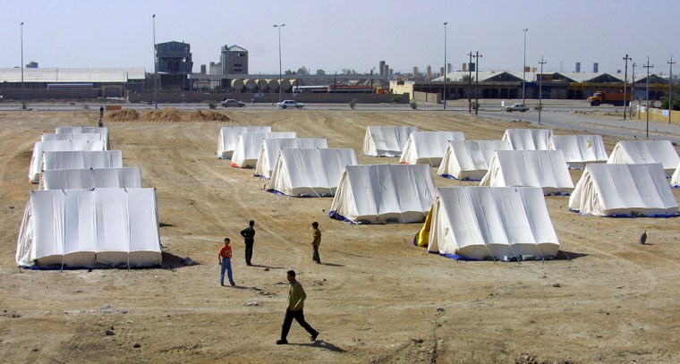 Iraqi Sunnis walk through lines of tents