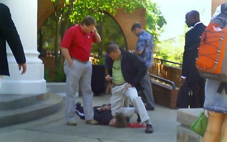 A photo taken with a student’s camera phone shows a federal Bureau of Alcohol, Tobacco and Firearms official pinning down Jeremiah Ransom in front of Snelling dining hall Tuesday on the University of Georgia campus in Athens, Ga.