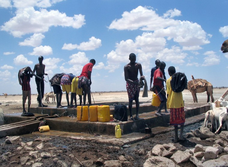 Men struggle to pull up water from a drying watering hole in Rabdore, Somalia, where a two-year war was recently fought over the resource.