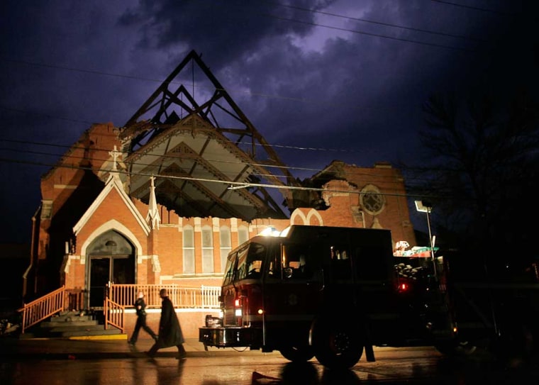 Firefighters inspect St. Patrick's Catholic Church in Iowa City, Iowa, after the part of the roof was ripped off as a tornado struck the city Thursday, April 13, 2006. Several tornadoes that ripped through eastern Iowa left some neighborhoods in disarray as heavy winds and hail destroyed cars, crushed homes and cut off power to thousands of Iowans.