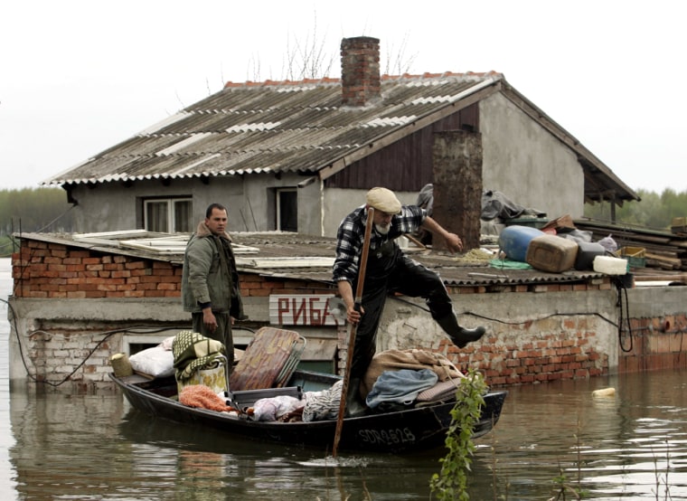 People remove items from a flooded home in the village of Oresac, near the Danube River, south of Belgrade on Sunday.