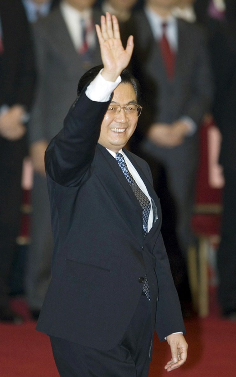 Chinese President Hu Jintao waves as he walks past Chinese and Taiwanese officials gathered for a photo session in China