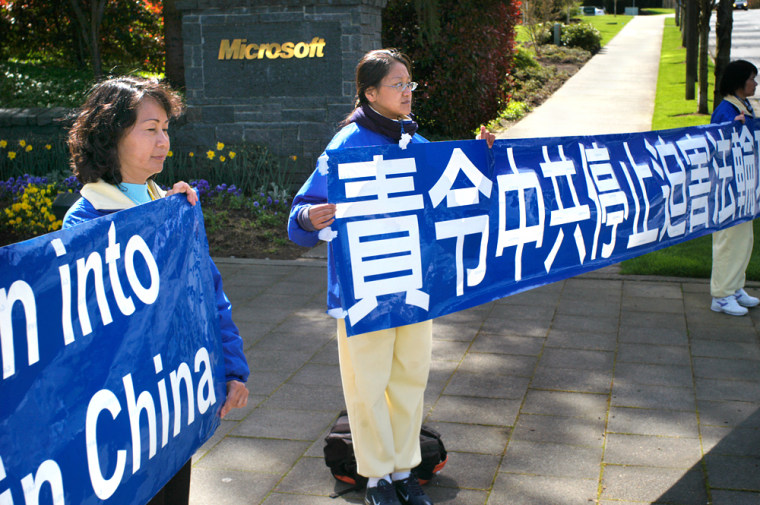 Protestors await the motorcade of Chinese president Hu Jintao prior to his visit to Microsoft's Redmond, Wash., campus on Tuesday, April 18, 2006.