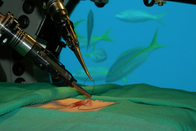 A robot aboard the Aquarius Undersea Laboratory on the ocean floor stitches together a simulated wound. A Canadian doctor sitting at a control interface 1,300 miles away directed the robot's movements.