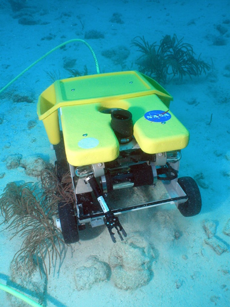 The Scuttle rover rolls along the ocean floor to collect samples and return them to the Aquarius Undersea Laboratory during NASA's NEEMO 9 mission.