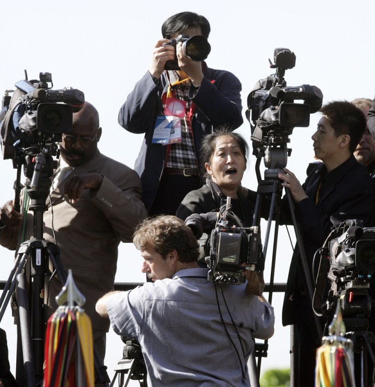 The protester screams in front of NBC cameraman Rodney Batten, in brown shirt to the left, during the arrival ceremony for Chinese President Hu Jintao on the South Lawn of the White House on Thursday.