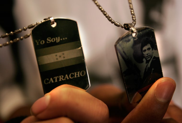 Students Teofilo Rubi shows his dog tag which says in Spanish, "I am Honduran"  (Catracho is slang for a male born in Honduras) and C'Andre Dabney shows off his, which features a picture of Al Pacino as Scarface.