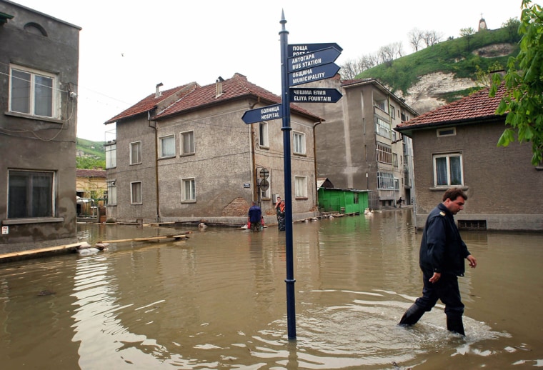 Bulgarian civil defense officer walks on flooded street in town of Nikopol