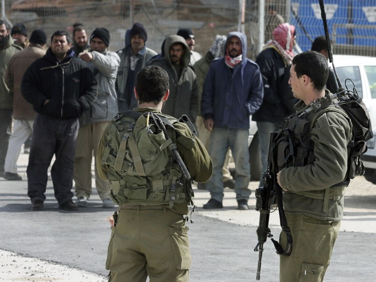 Israeli soldiers keep an eye on a group