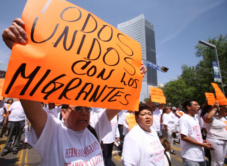 Mexicans hold placards during march in Mexico City in favour of migrants in the U.S.