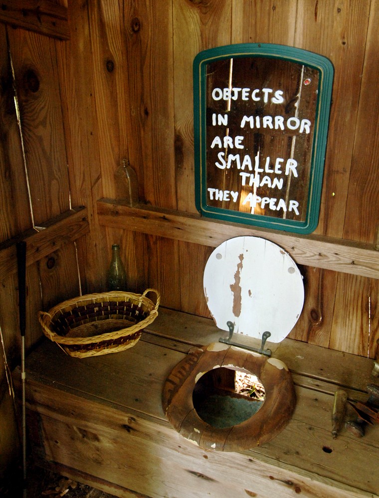 The inside of one of the outhouses owned by Janie Peel, is shown on April 25, 2006, in her backyard in Appling, Ga. The outhouse features a real toilet seat and a mirror on the wall. Peel has three behind her home, with room for a dozen more. (AP Photo/The Augusta Chronicle, Jim Blaylock) ** NO SALES, MAGS OUT**