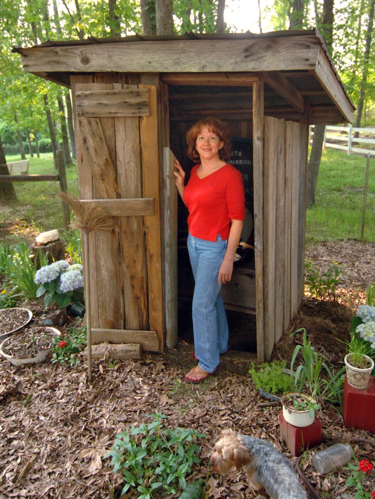Commercial real estate broker Janie Peel shows off one of her collection of outhouses April 25 in her back yard in Appling, Ga.