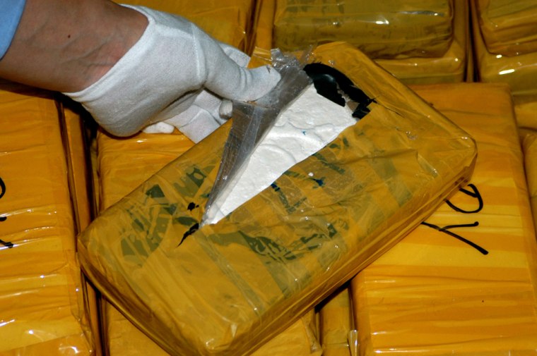 In this photo released by China's Customs Administration, a policeman displays cocaine after it was seized in China's southern Guangdong province on March 15, 2006. Chinese and U.S. agents on Tuesday May 9, 2006 announced the arrests of nine people and confiscation of 142.7 kilograms (314 pounds) of smuggled cocaine in the country's largest ever seizure of the drug. (AP Photo/China Customs Administration, HO)