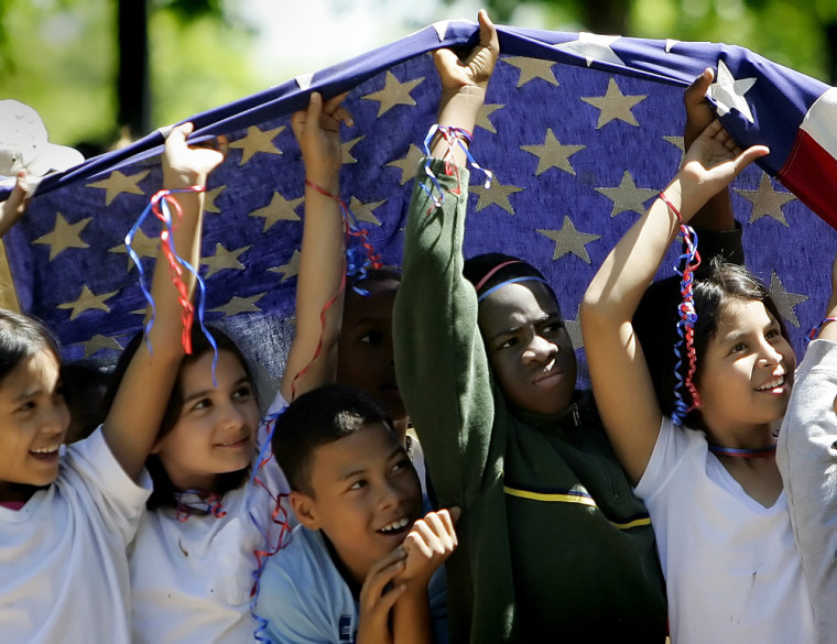 Young children hold up an America flag a