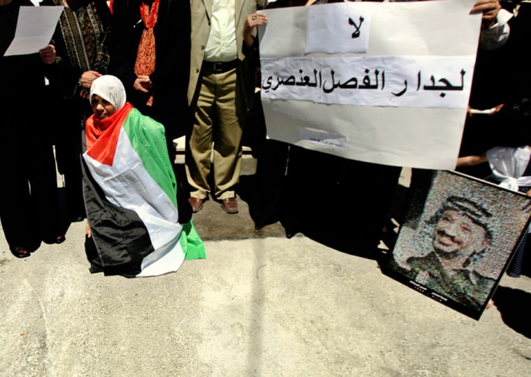 A Palestinian woman wrapped in the Palestinian flag participates in a protest Thursday against the internal Palestinian fighting outside the Palestinian Legislative Council in the West Bank town of Ramallah. Senior members of the rival Hamas and Fatah factions have forged a joint platform, including acceptance of a Palestinian state alongside Israel.