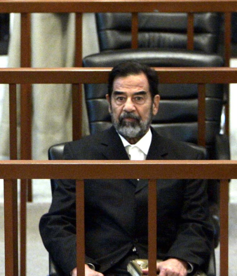 Former Iraqi President Saddam Hussein listens to charges read by Judge Raouf Abdel Rahman during his trial in Baghdad's heavily fortified Green Zone on Monday.