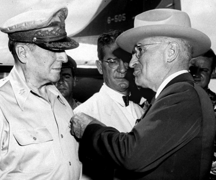 President Truman, left, pins the Distinguished Service Medal on the shirt of Gen. Douglas MacArthur during a ceremony at the airstrip on Wake Island, in an Oct. 14, 1950, file photo. In the center is John J. Muccio, United States ambassador to Korea and author of the letter.