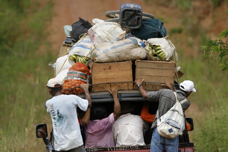 People standing on the side of a truck take their goods through an inside road at Brazil's Amazonia National Park, where hundreds if not thousands of families have cut out small ranches.