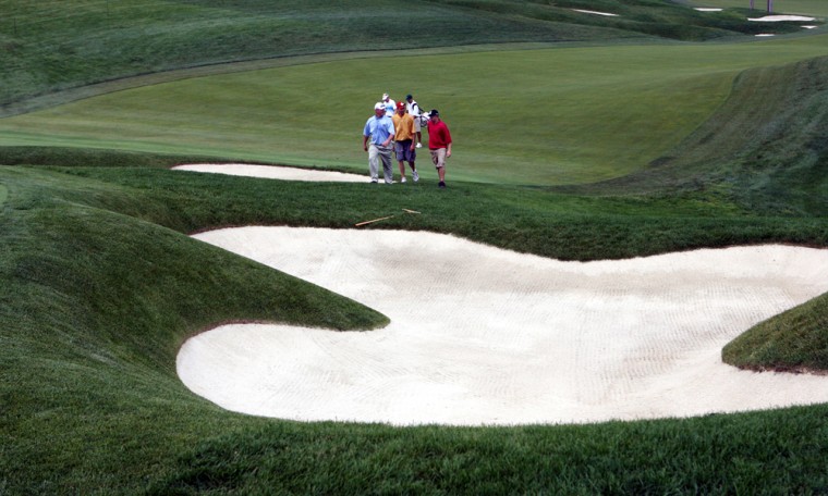 A group of players approach the bunker on the 18th hole at the Muirfield Village Golf Club, in Dublin, Ohio.