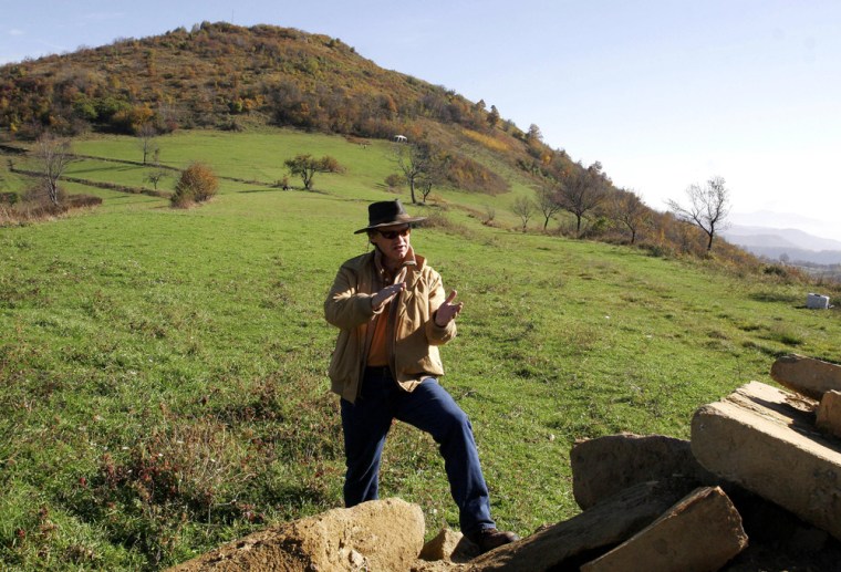 Amateur archaeologist Semir Osmanagic stands at the foot of a hill that he claims is an ancient pyramid.