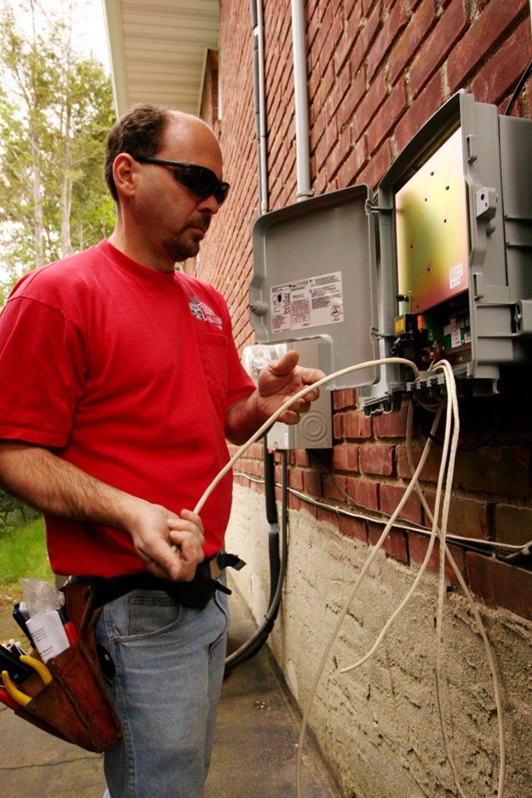 ** ADVANCE FOR MONDAY JUNE 12 **Verizon installer Pat Esposito connects wires to a fiber optic signal box on the side of a home in North Bellmore, N.Y. on May 11, 2006. Verizon is making a big bet that the time is right to replace its copper phone lines with optical fiber. It's an expensive gamble that has punished the company stock, but at the front lines of this minor revolution, in the homes that are being connected, it's clearly a popular endeavor. (AP Photo/Mark Lennihan)