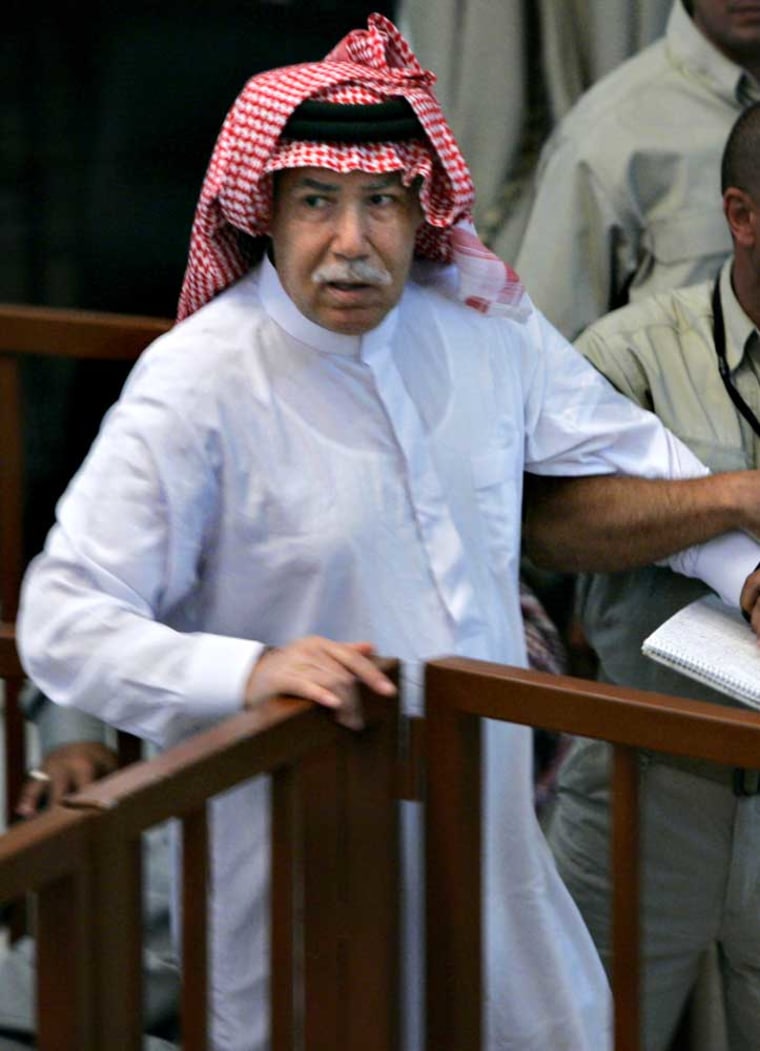 Saddam Hussein's former intelligence chief and half-brother Barzan al-Tikriti is removed from court by guards after arguing with the judge on Monday in Baghdad.