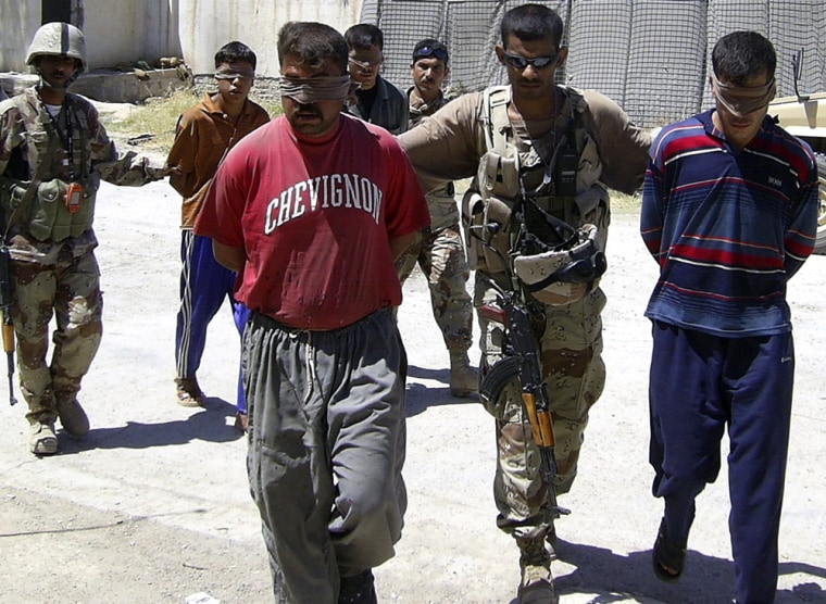 Iraqi soldiers escort suspected insurgents after they were arrested during a raid in a village near Baquba