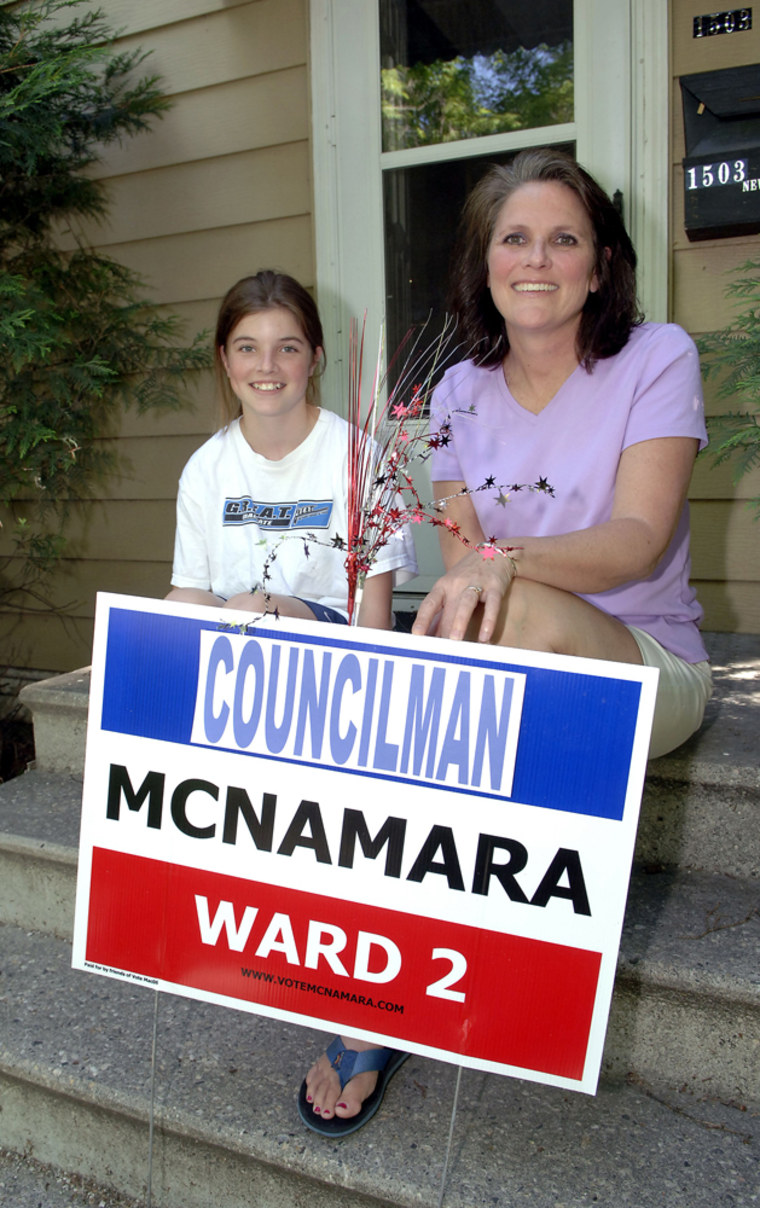 Mike McNamara's daughter Katherine McNamara, 12, and his wife Susan McNamara sit behind one of his campaign signs on the front steps of their home in Grand Forks, N.D., on Wednesday.