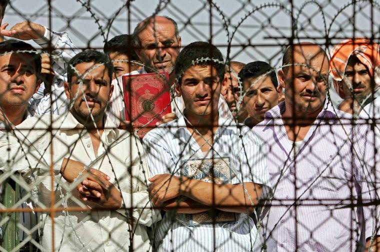 Some of the 200 Iraqis wait to be released from Abu Ghraib under a national reconciliation plan announced by Prime Minister Nouri al-Maliki the previous week, in Baghdad, Iraq, Thursday, June 15, 2006. Under the plan, 2,500 inmates will be released. (AP Photo/Ali Jasim, Pool)