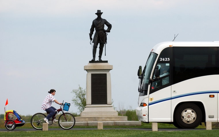 ** ADVANCE FOR SUNDAY JUNE 18 AND THEREAFTER ** A tour bus and cyclist meet at a bronze statue of U.S. Army Brevet Major General Alexander Stewart Webb, Tuesday, May 3, 2005, in Gettysburg National Military Park in Gettysburg, Pa. Gettysburg may also become home to a slot-machine casino, a prospect that investors say will pump up the area's economy, but that some Civil War historians and preservationists worry will sully the heritage of the community and sprawling Gettysburg National Military Park. (AP Photo/Carolyn Kaster)