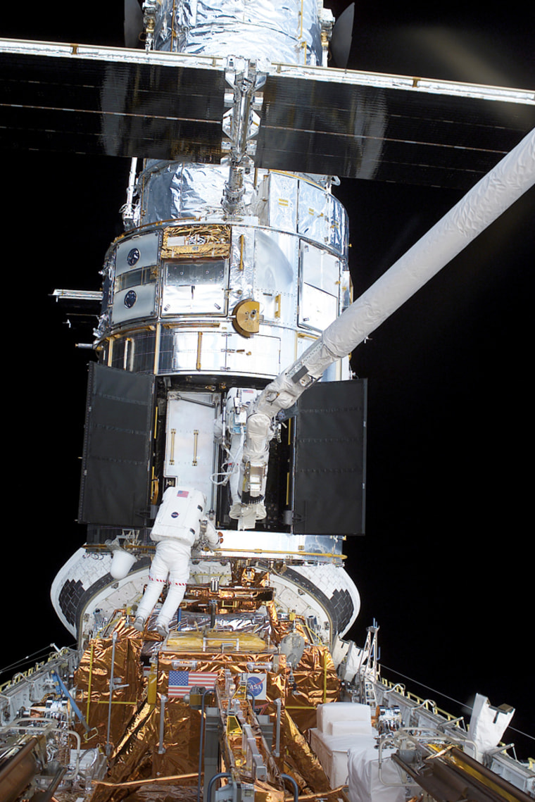Astronauts Jim Newman and Michael Massimino work on the installation of the Hubble Space Telescope's Advanced Camera for Surveys during a spacewalk in March 2002. The ACS stopped working last week, and experts are troubleshooting the problem.