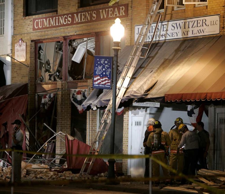 Rescuers gather in front of the collapsed Elks Lodge in downtown Clinton, Mo., late Monday night.