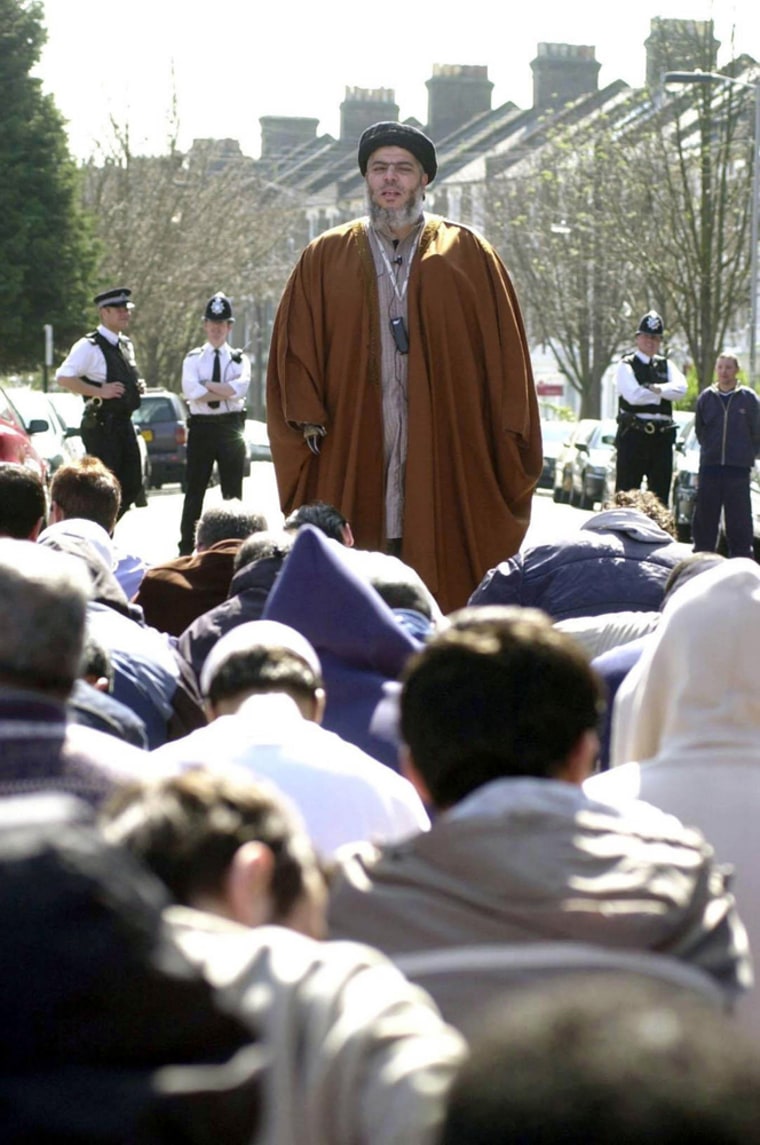 ** FILE **  Radical Muslim cleric Abu Hamza al-Masri, top, preaches in a street near London's Finsbury Park mosque in this April 2003, file photo, A jury sitting at London's, Old Bailey Court convicted radical Muslim cleric Abu Hamza al-Masri on Tuesday Feb. 7, 2006, of fomenting racial hatred and inciting followers to kill non-Muslims. Al-Masri, 47, the former imam at London's Finsbury Park mosque was also found guilty of possessing a terrorist document as well as threatening or abusive recordings. Al-Masri, Britain's best-known Islamist orator, could receive a maximum sentence of life in prison. The jury of seven men and five women found al-Masri guilty on seven of nine charges of soliciting murder. He was also convicted on two of four charges of stirring racial hatred.  (AP Photo/Johnny Green/PA/file) **  UNITED KINGDOM OUT NO SALES NO ARCHIVE **