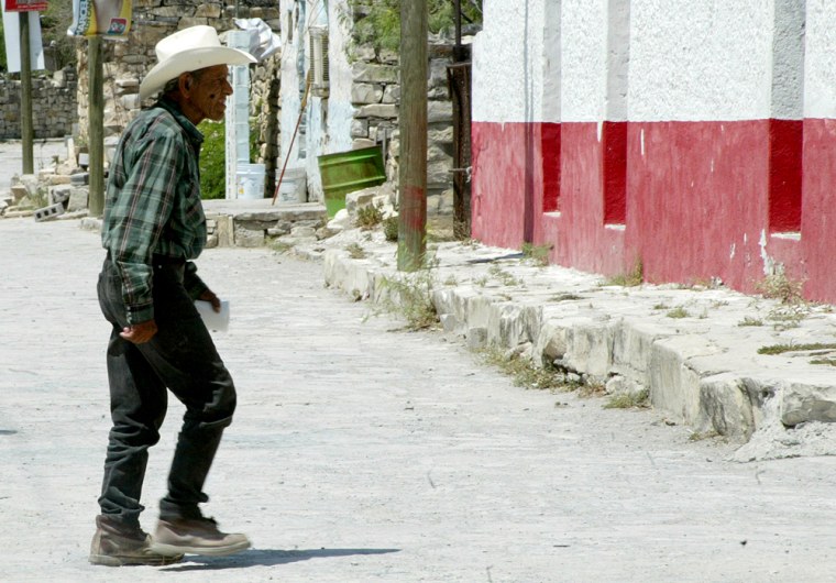 A man crosses a street in the nearly deserted border town of Vallecillo, Mexico on June 16. Officials had to beg residnets to staff the town's polling places for the hotly contested presidential election.