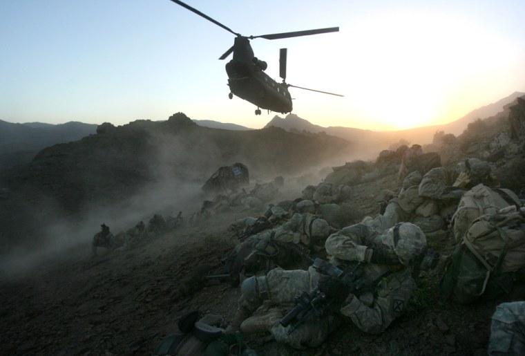 ** ADVANCE FOR Tuesday, July 4 **U.S. soldiers shelter themselves from the rotarwash of a Chinook helicopter after being dropped off on a mountain ridge in the Baghran Valley of Helmand province, Sunday, June 18, 2006.  The soldiers were on a mission in support of Operation Mountain Thrust, an offensive to root out Taliban militants in southern Afghanistan. From top generals to ground-level lieutenants, the U.S. military here touts the same plan for success: Extend the reach of the Afghan government.  (AP Photo/Rodrigo Abd)