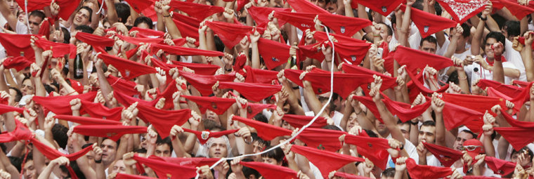Revelers hold up traditional red neckties during the official opening of the San Fermin fiestas in Pamplona, Spain, on Thursday. The fiestas 'Los San Fermines' held since 1591, attracts tens of thousands of foreign visitors each year for nine days of revelry, morning bull-runs and afternoon bullfights.